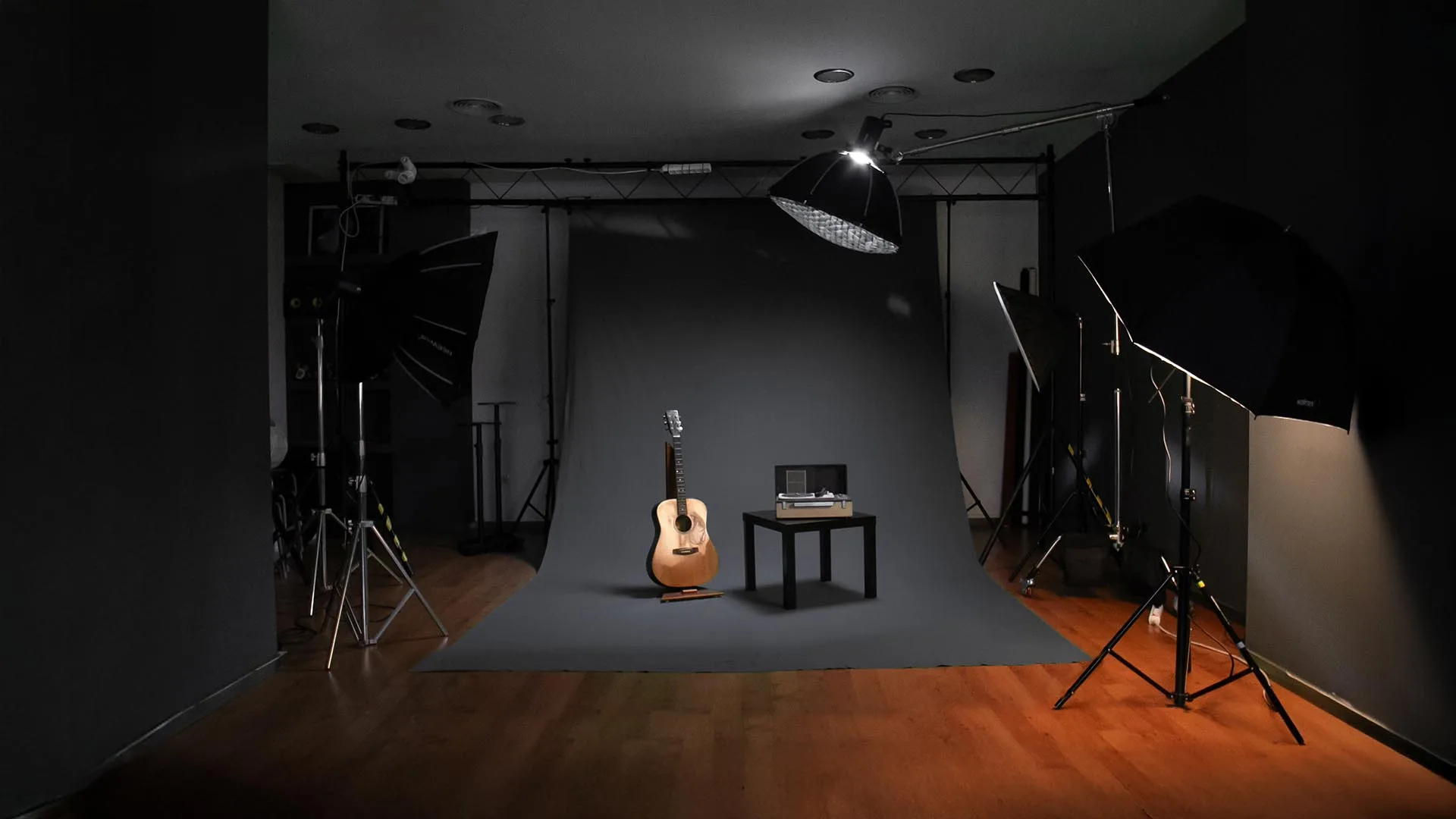Estudio de grabación de Evolutiva en Córdoba, con fondo gris, focos y una guitarra